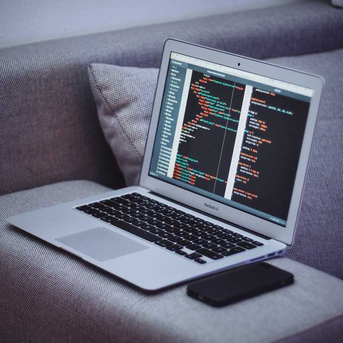 Laptop screen filled with code sitting on a couch