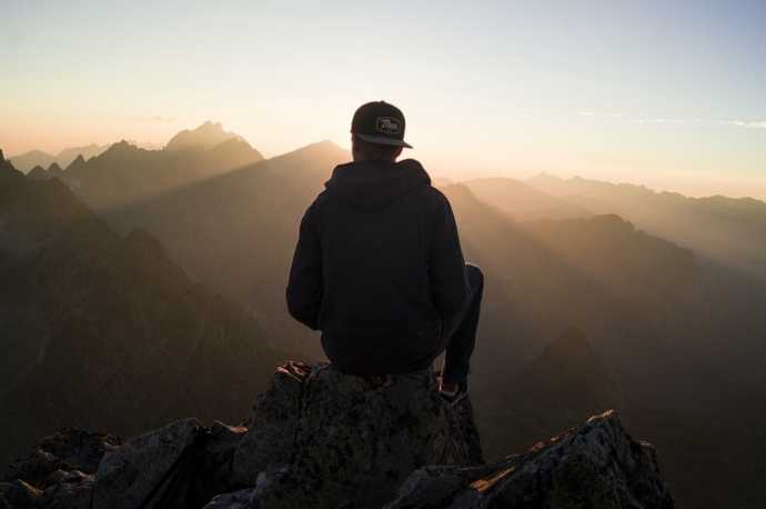 hiker looking out over many mountains yet to climb